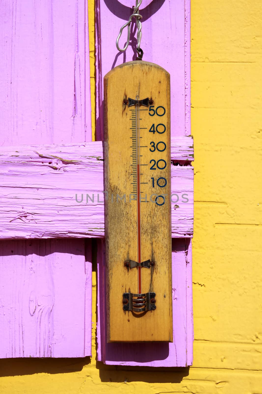 Old thermometer hang on a wooden background