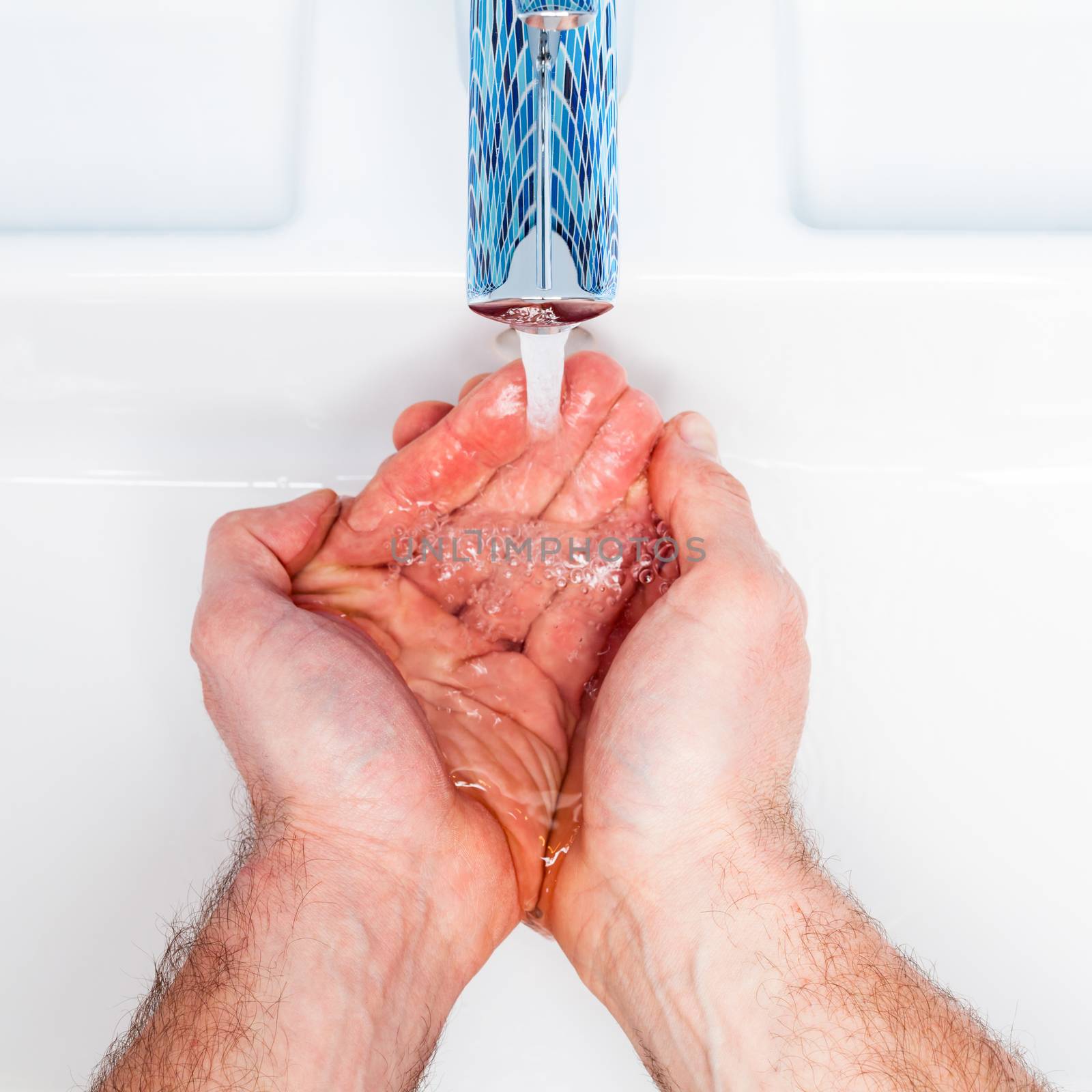 Man washing his hands in a bathroom sink