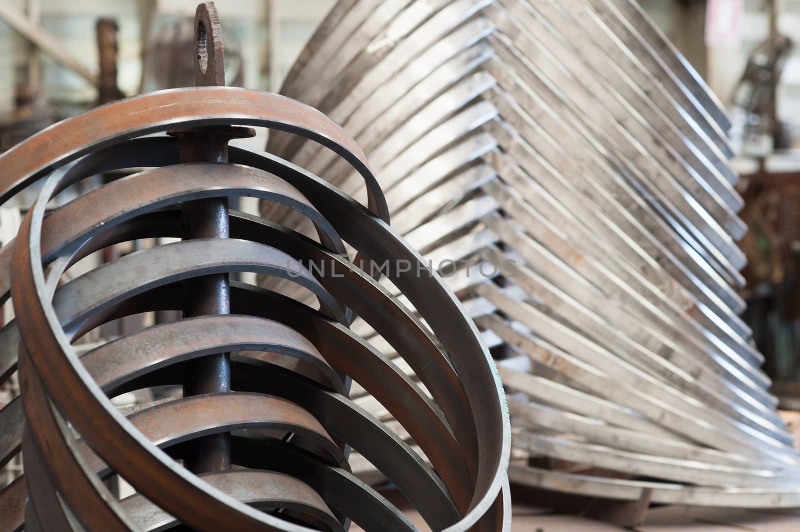 Conventional mild steel rings in the foreground and stainless steel rings in the background at industrial workshop. Shallow depth of field with part of the foreground rings in focus.