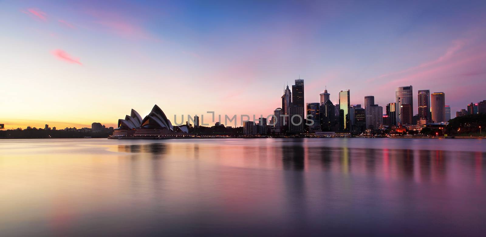Sydney city skyline of office buildings and skyscrapers and Opera House along Sydney Harbour in the morning at sunrise