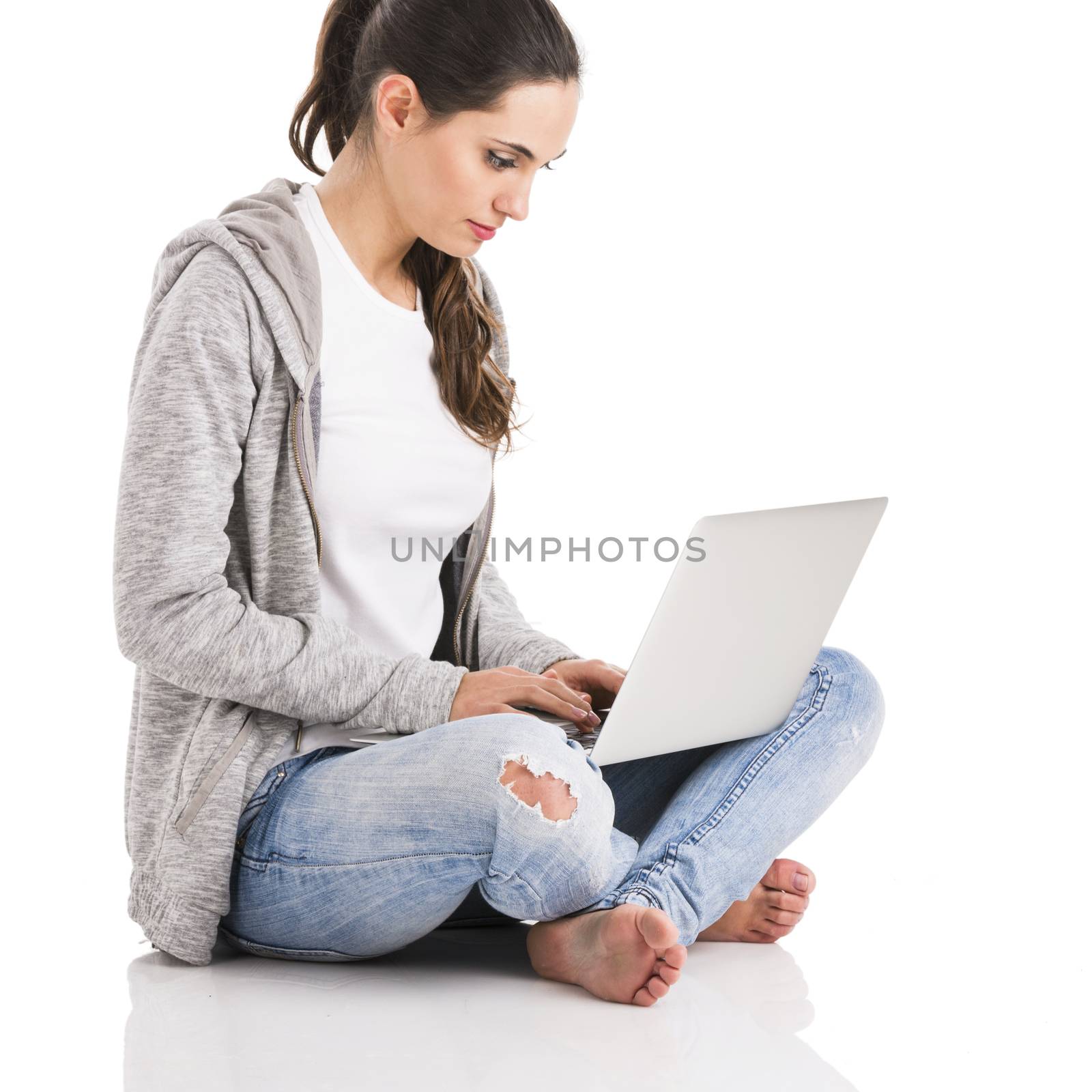 Beautiful woman sitting in the floor and working with a laptop