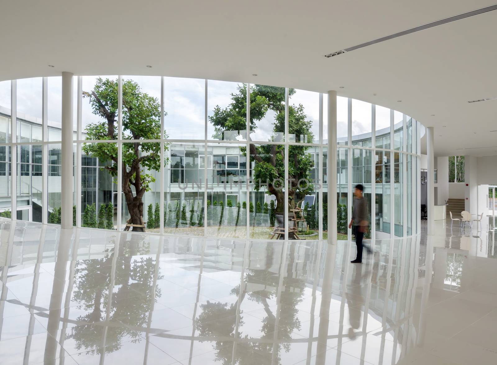 Glass wall in the modern building with people walking in motion blur 