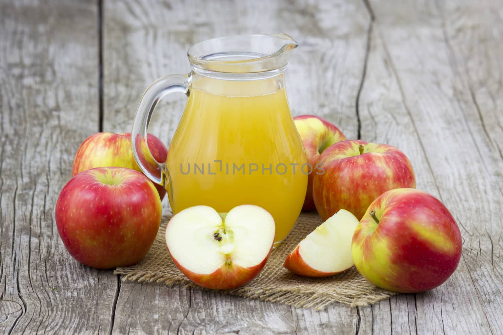 Apple juice and apples on wooden background