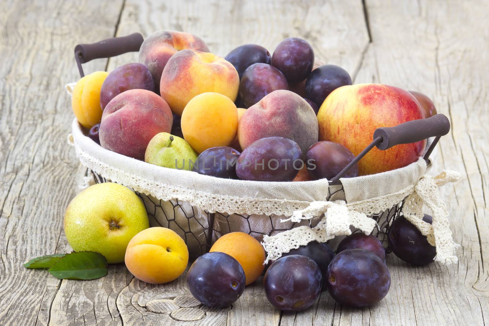 fresh fruits in a basket on wooden background