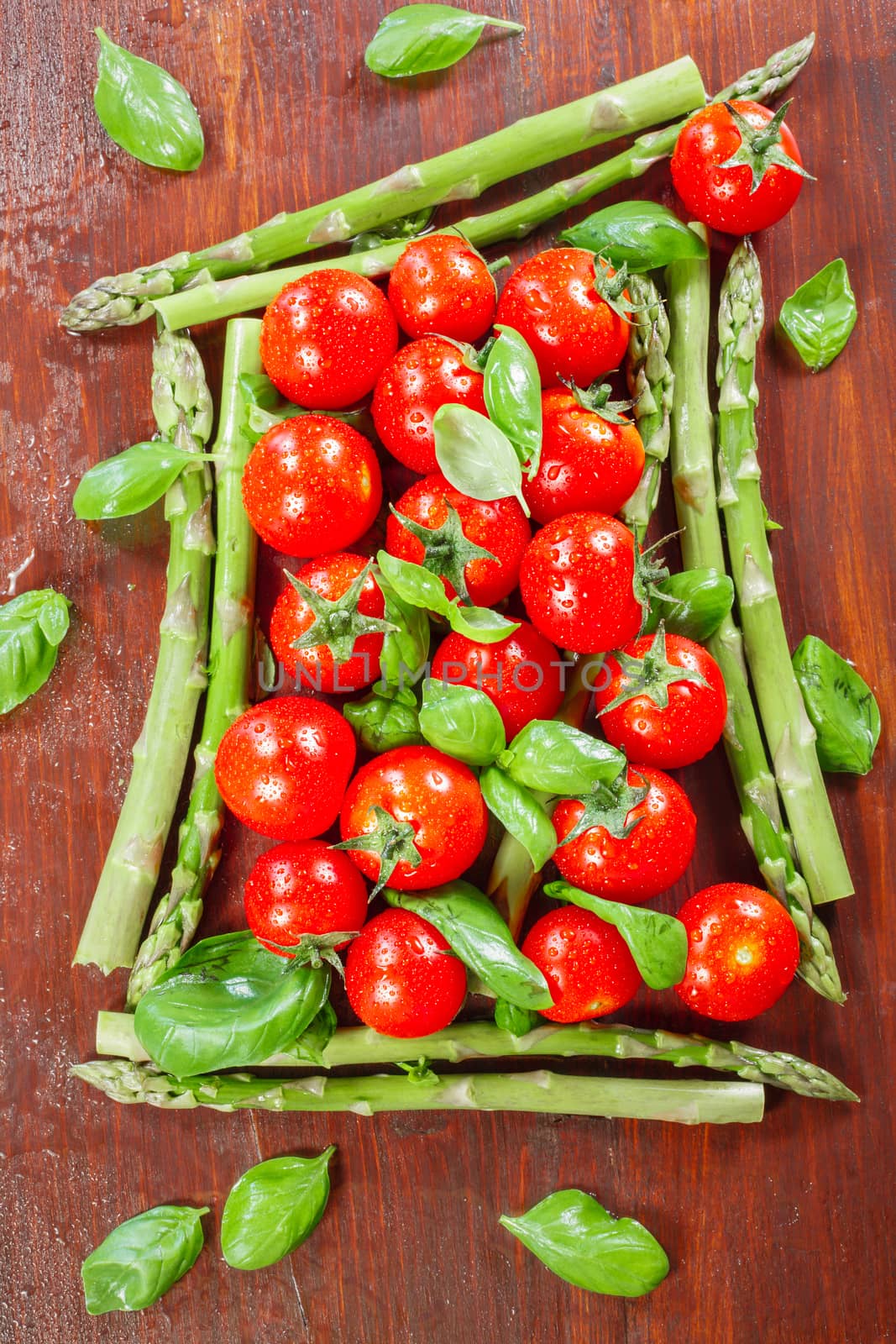 Fresh Asparagus and Cherry Tomatoes on a wooden background