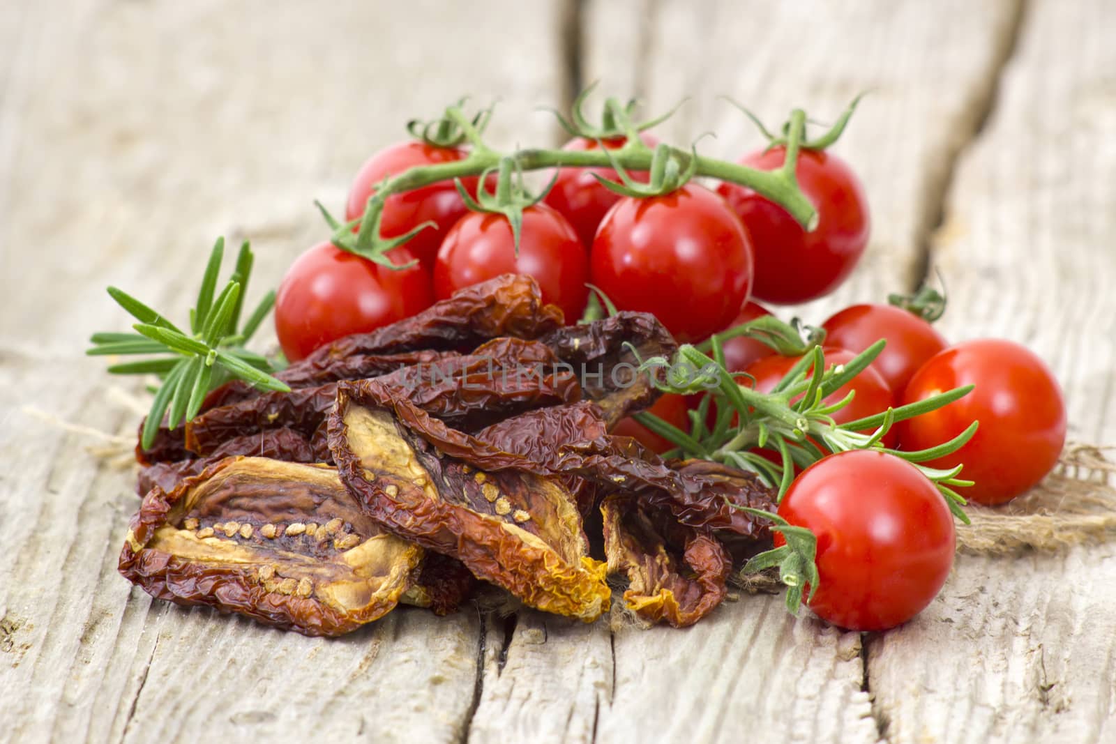 fresh and dried tomatoes on wooden background