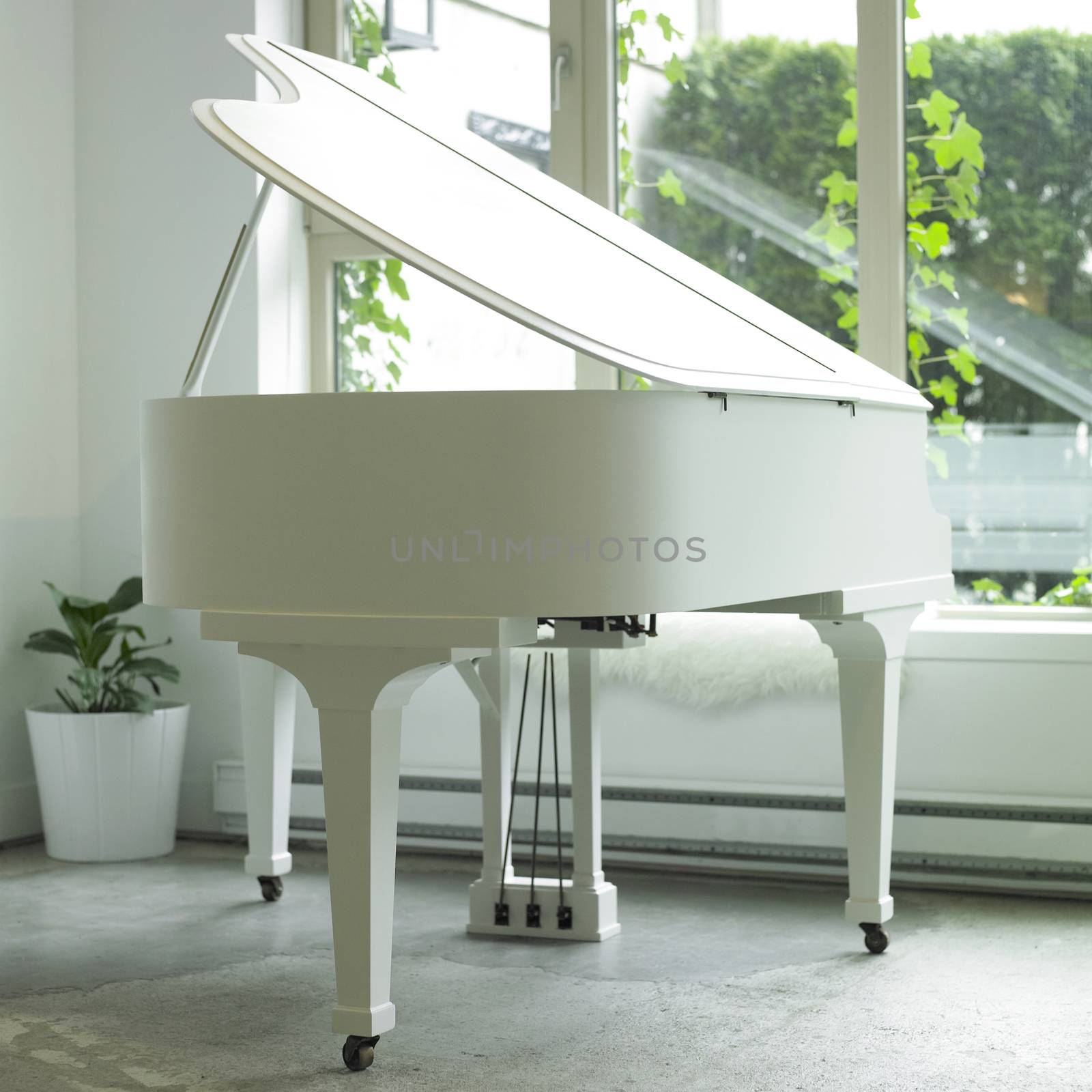 White baby grand piano in a white room