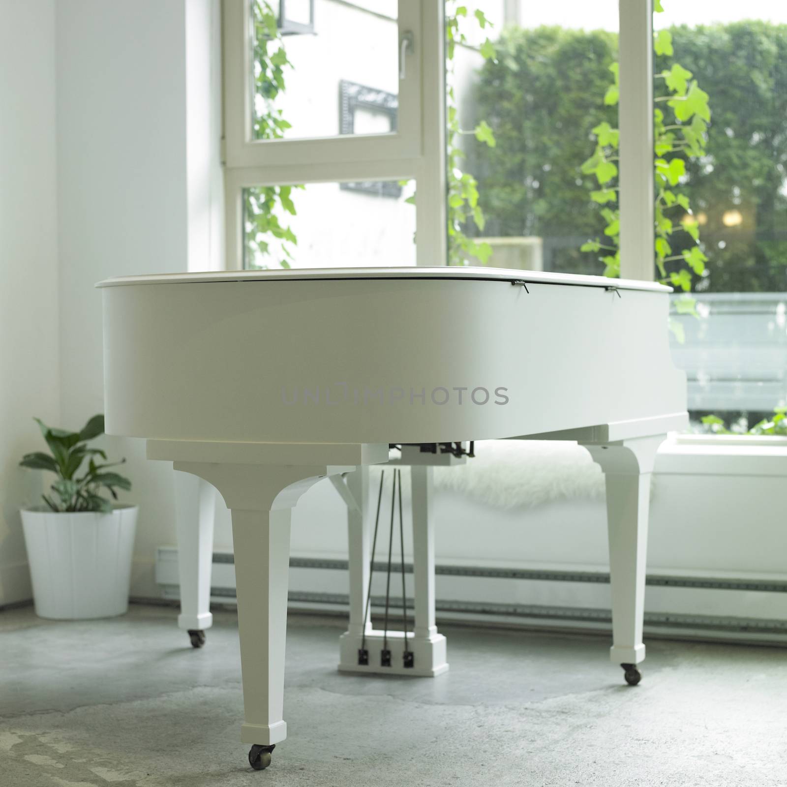 White baby grand piano in a white room