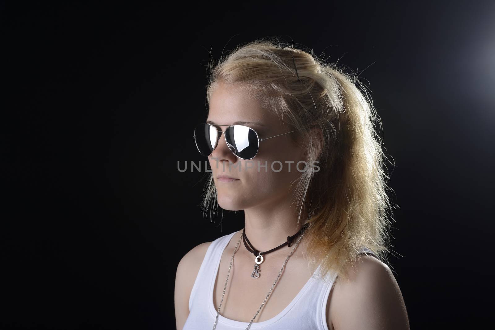 young blond woman with sunglasses against black background