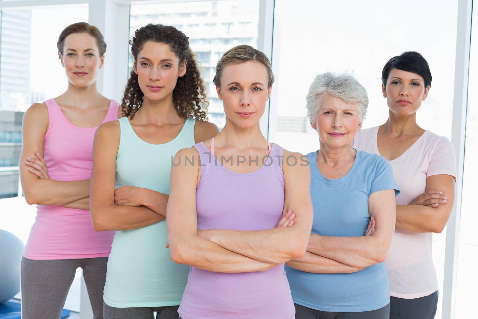 Confident women with arms crossed in yoga class by Wavebreakmedia