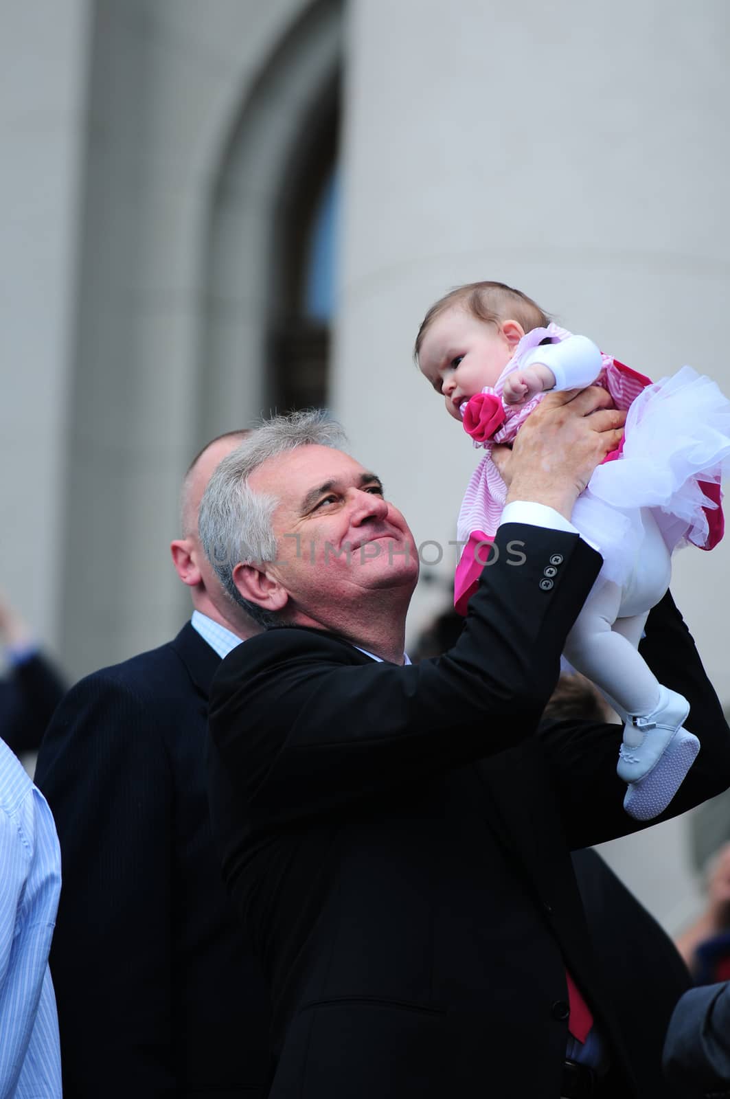 SERBIA, BELGRADE - MAY 31, 2012: President of Serbia Tomislav Nikolich holding his granddaughter high in the air on his inauguration day