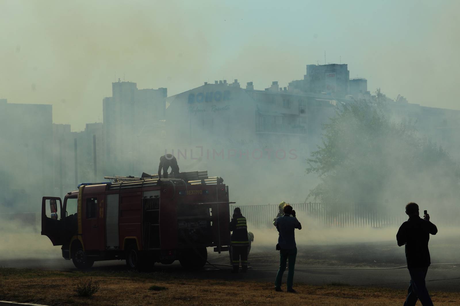 SERBIA, BELGRADE - JULY 22, 2012: Firemen at work trying to control fire at burning field in New Belgrade's district