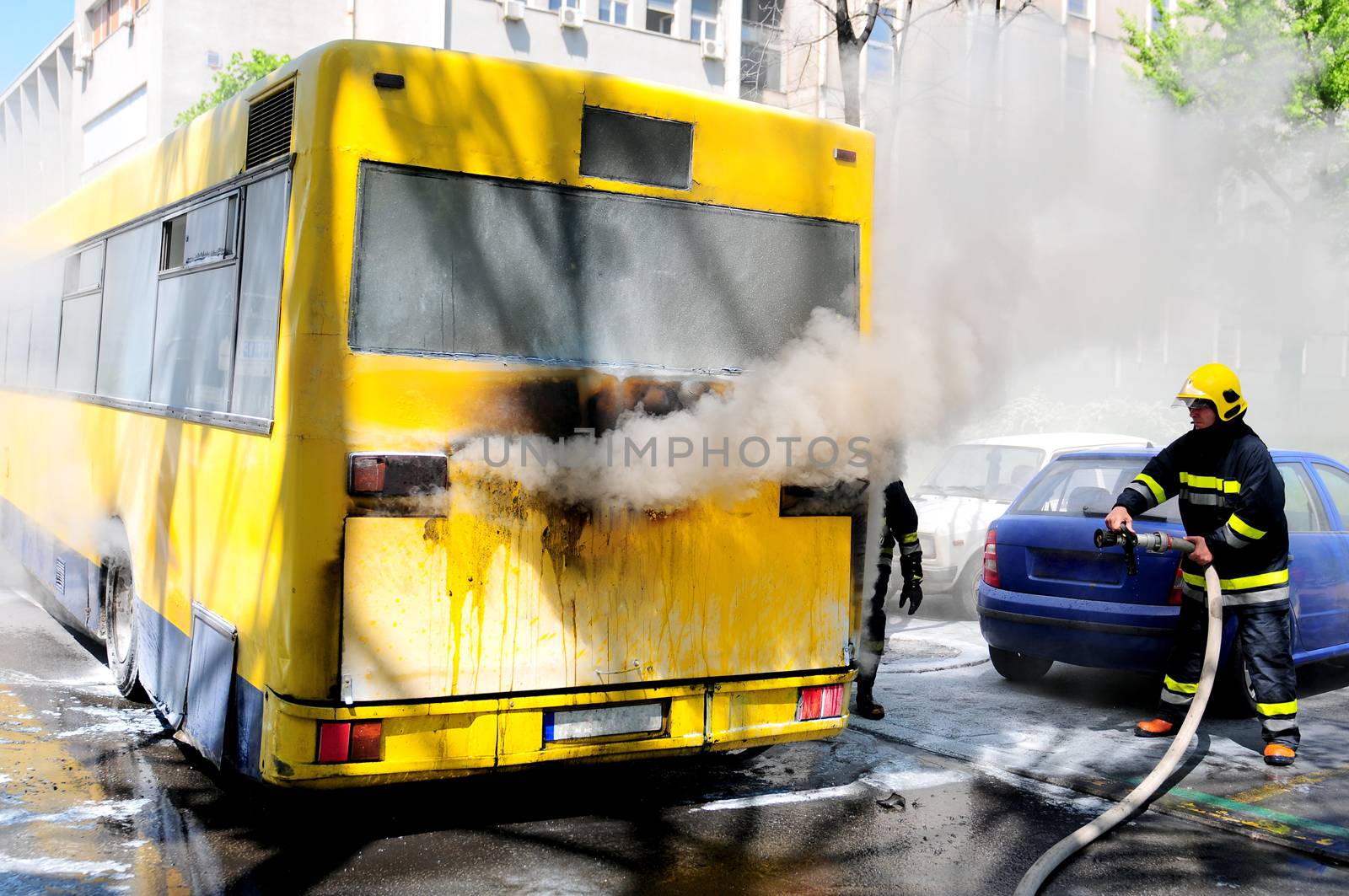 SERBIA, BELGRADE - APRIL 27, 2012: Fire fighters tries to extinguish burning bus on the street