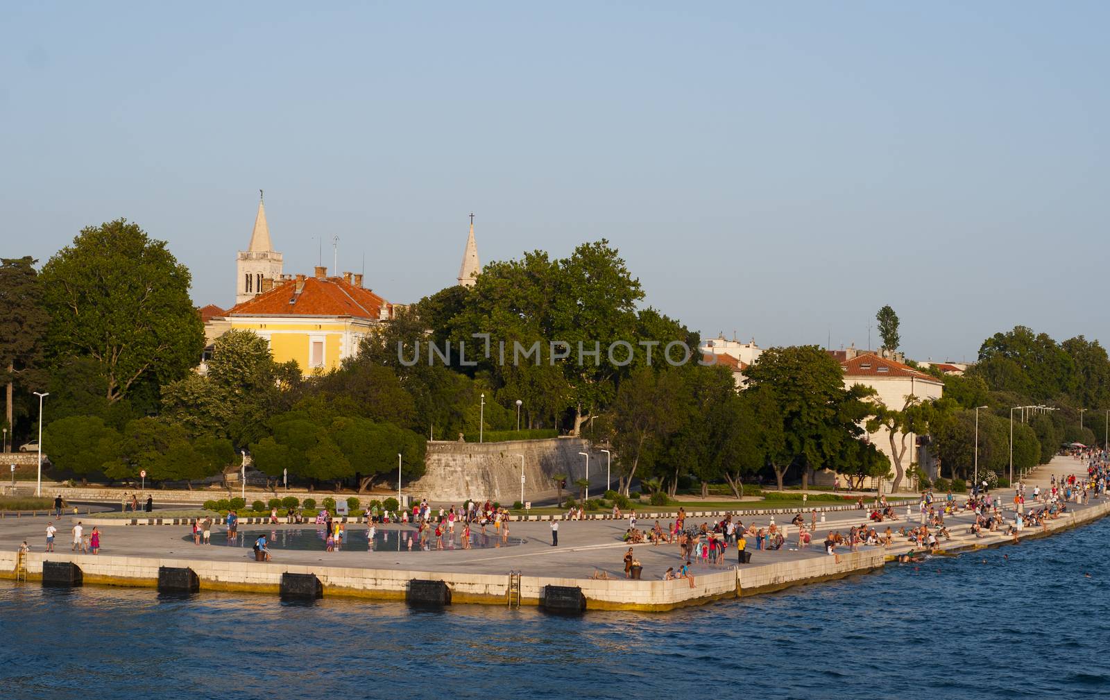 CROATIA, ZADAR - JULY 14, 2012: People walking along Adriatic sea, next tocircular solar panel urban installation "Greeting to the Sun"