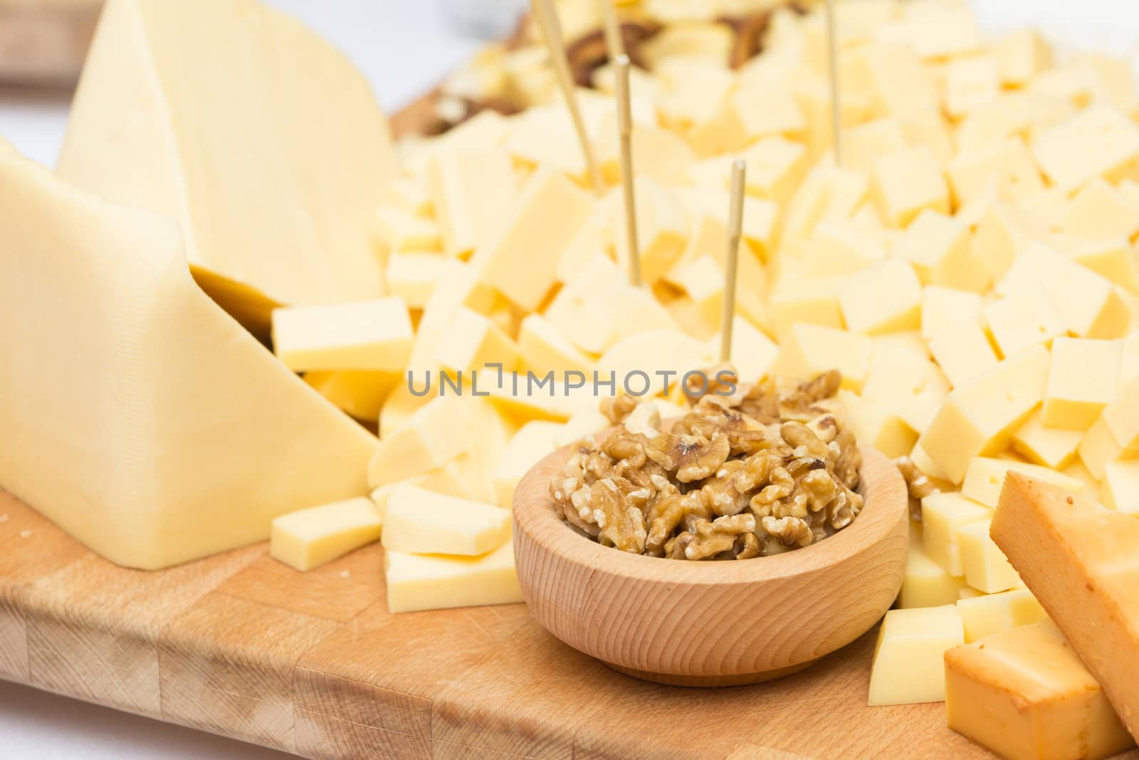 Cheese Plate with Dried Fruit, Nuts and Honey. Rustic decoration on a wooden plate.