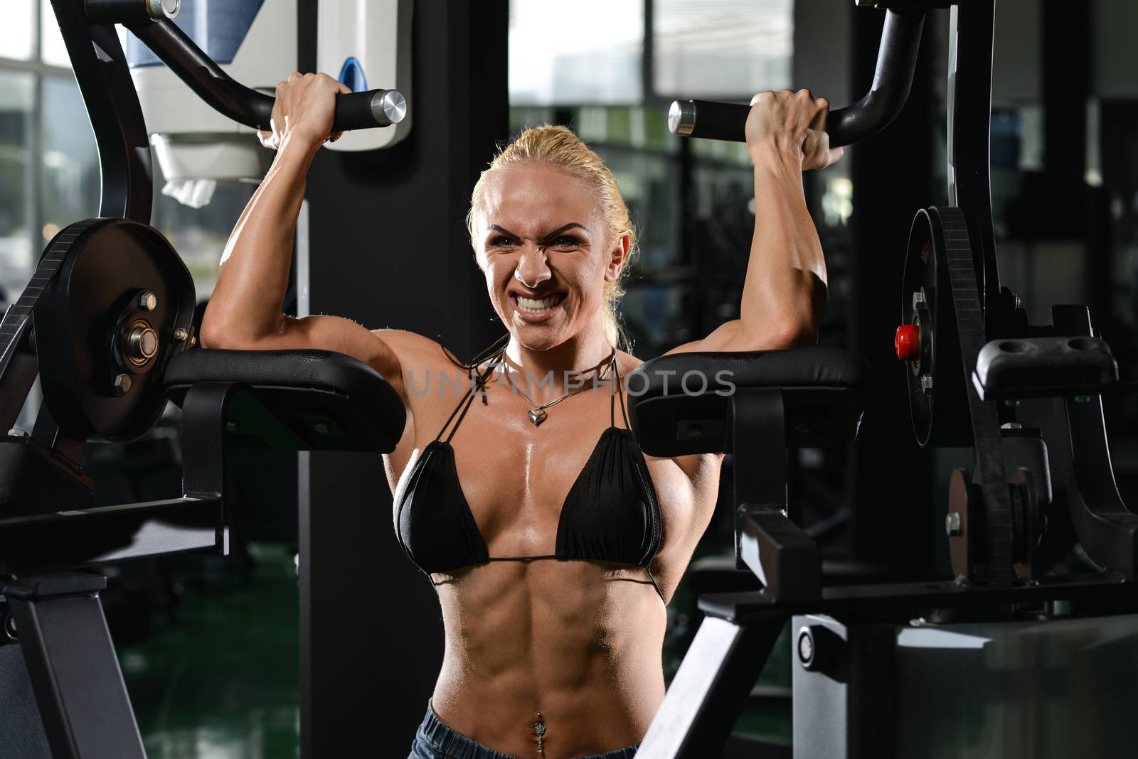 Female Bodybuilder Doing Heavy Weight Exercise For Biceps