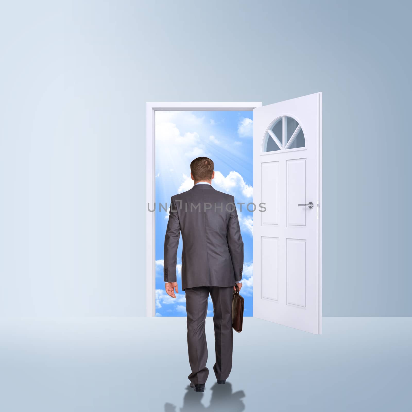 Businessman in suit with briefcase stepping through door. Sky as backdrop. Business concept