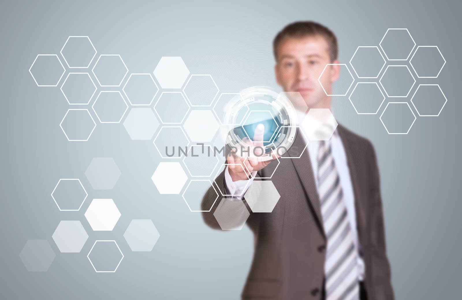 Businessman in suit finger presses virtual button. Transparent hexagons and glow circles as backdrop