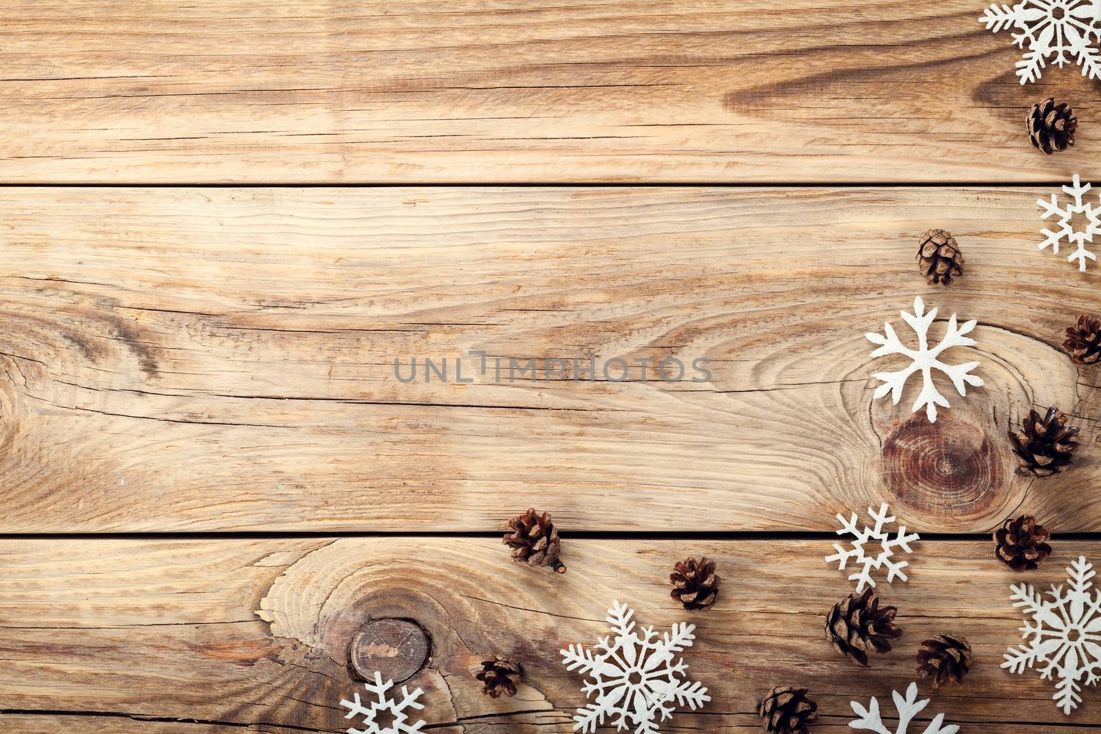 Christmas background with snowflakes and cones on wooden table with copy space. Top view