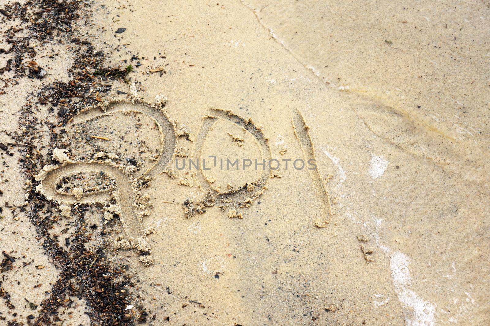 New year concept: year 2014 (or other number) written on the beach being washed away by a wave