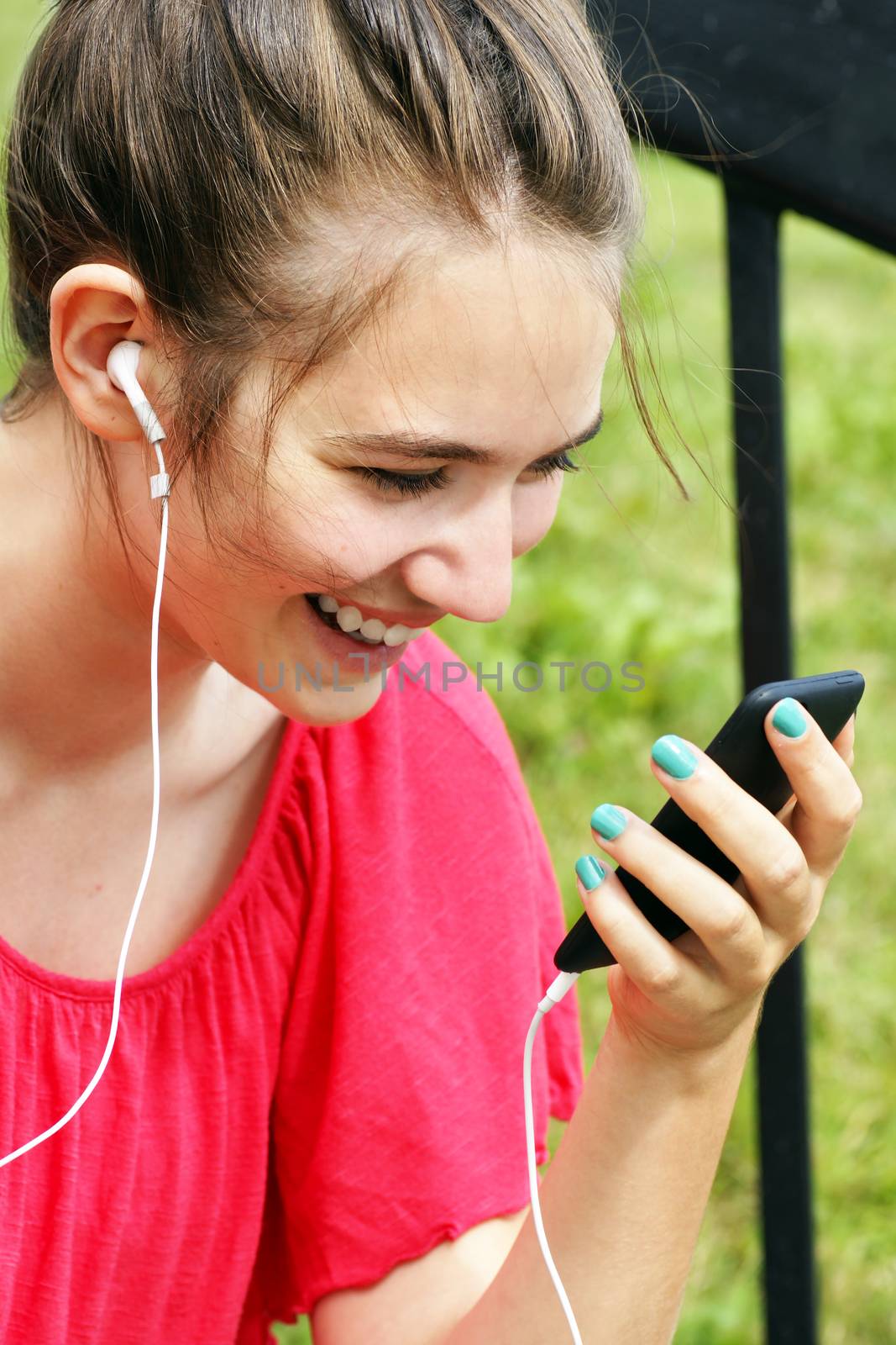 Young woman smiling at phone by Mirage3