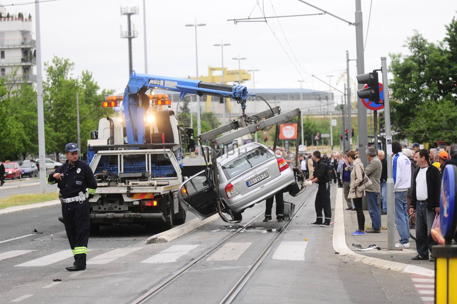 SERBIA, BELGRADE - MAY 12, 2013: Car towing truck takes away damaged black car after accident with tram. The car did not give priority to tram