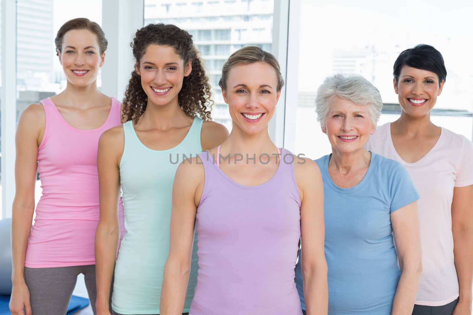 Smiling women standing in yoga class by Wavebreakmedia