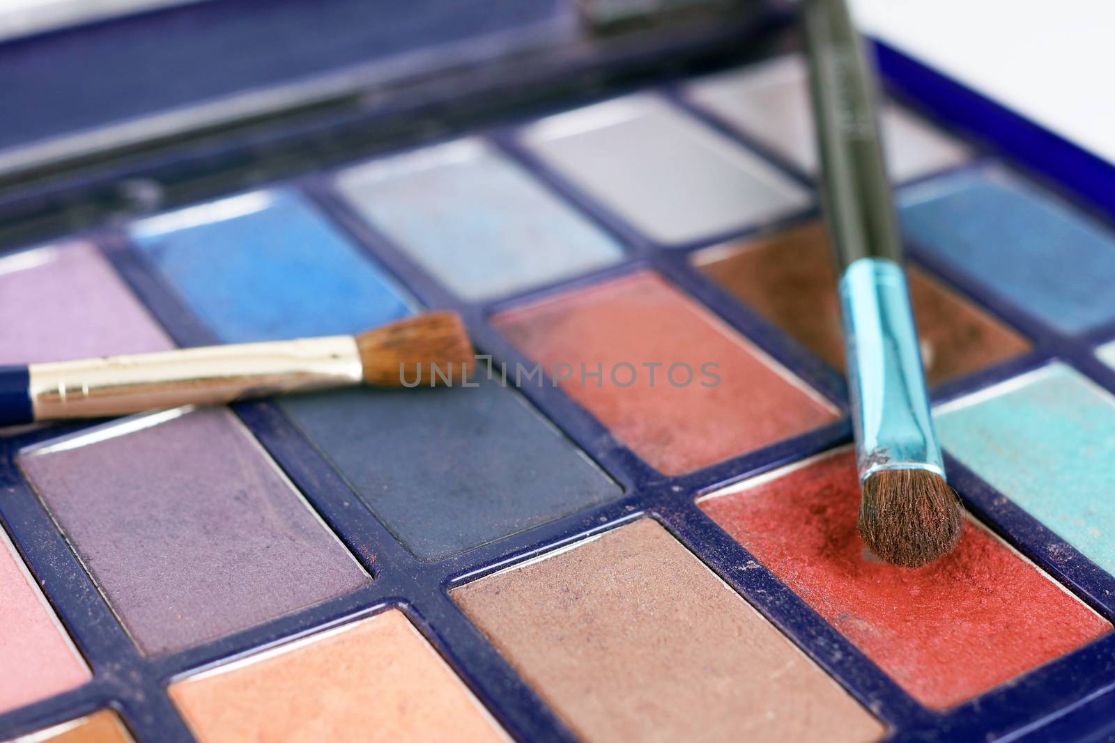 Macro of colorful eye shadow powders and brushes