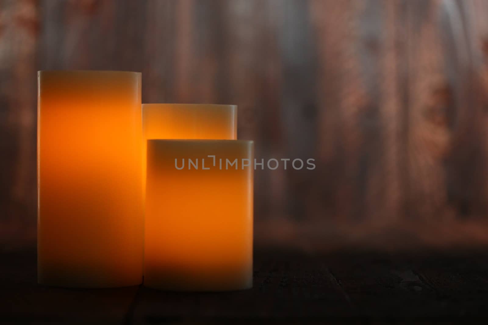 Lit Candle on an Old Wooden Rustic Background by tobkatrina