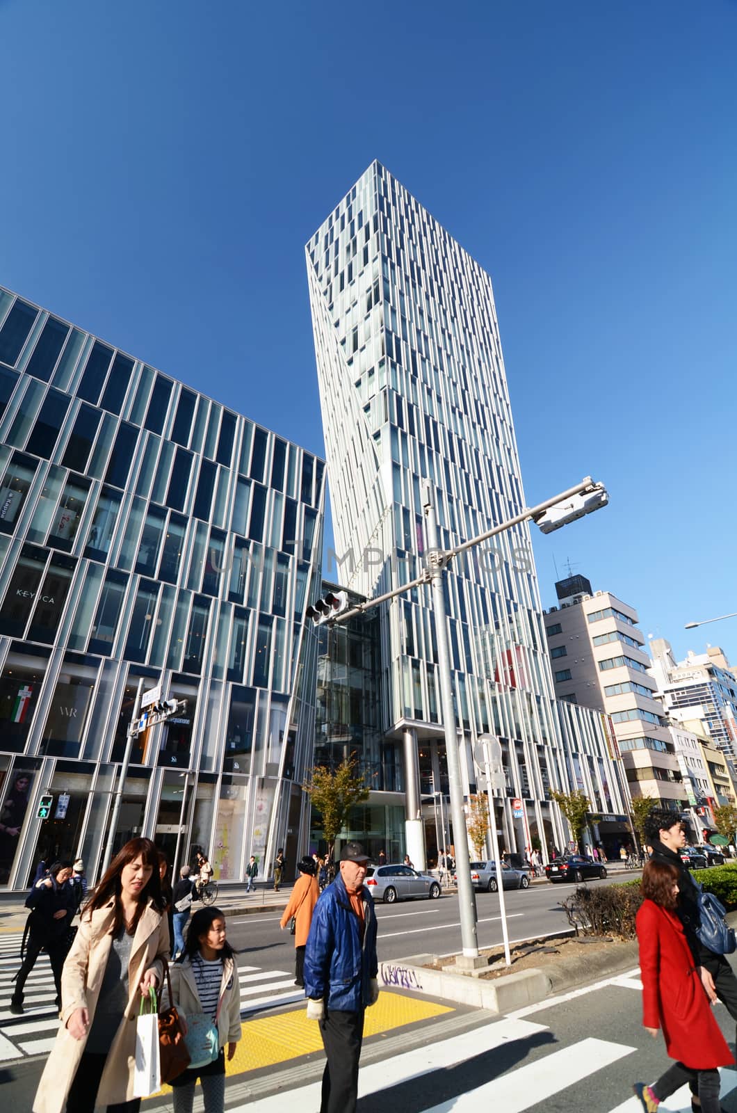 Tokyo, Japan - November 24, 2013: People walk by Futuristic Architecture on Omotesando Street on November 24. 2013, Omotesando street sometimes referred to as Tokyo's Champs-Elysees. Here you can find famous brand name shops, cafes and restaurants for a more adult clientele.