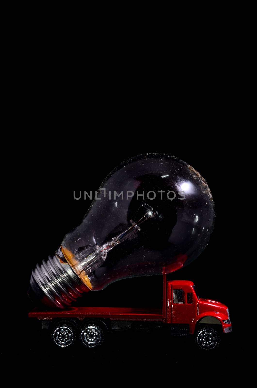 Electric Power Concept Red Truck and Light Bulb on a Black Background