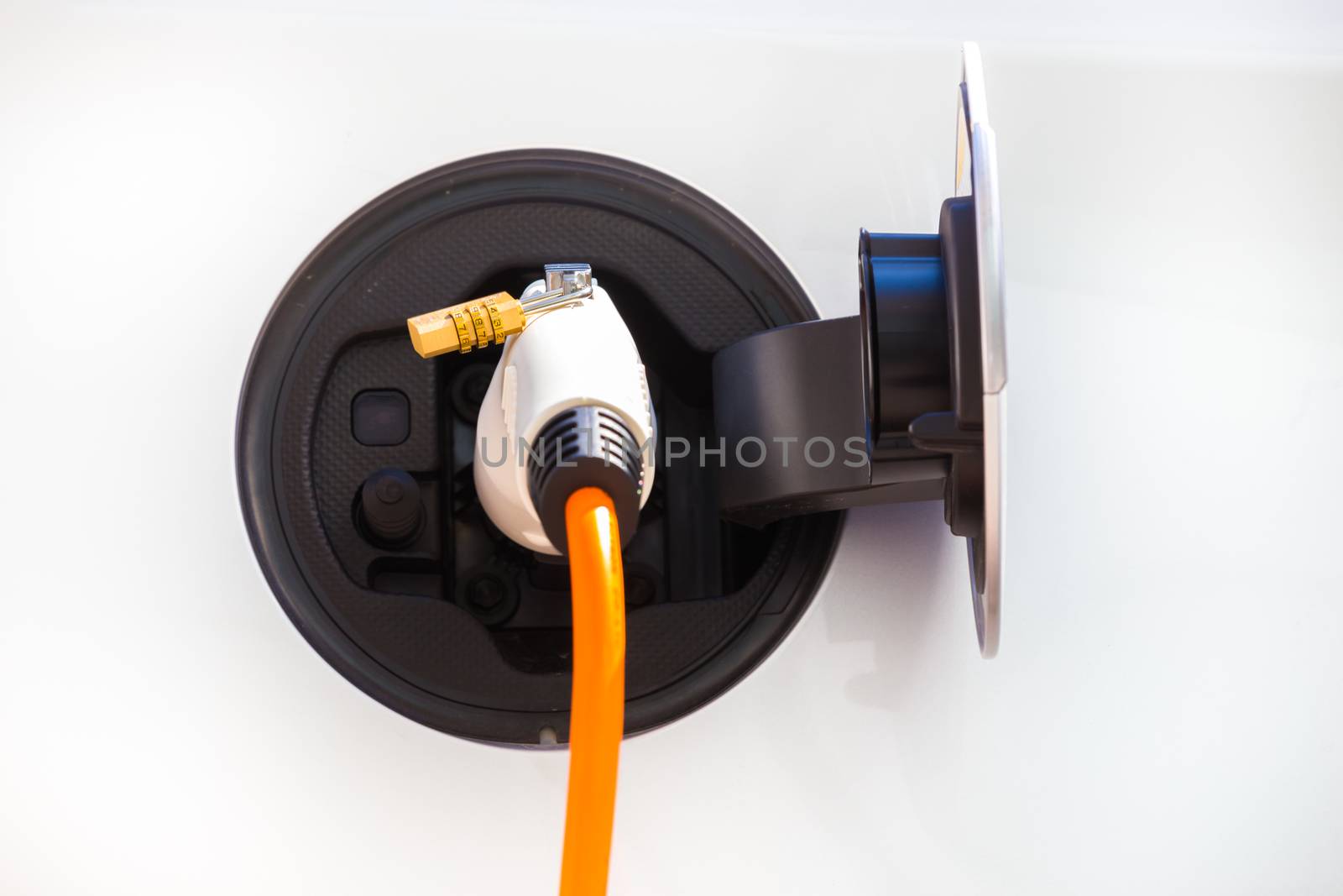 Detail power supply for electric car charging.  Electric car charging station. Close up of the power supply plugged into an electric car being charged.