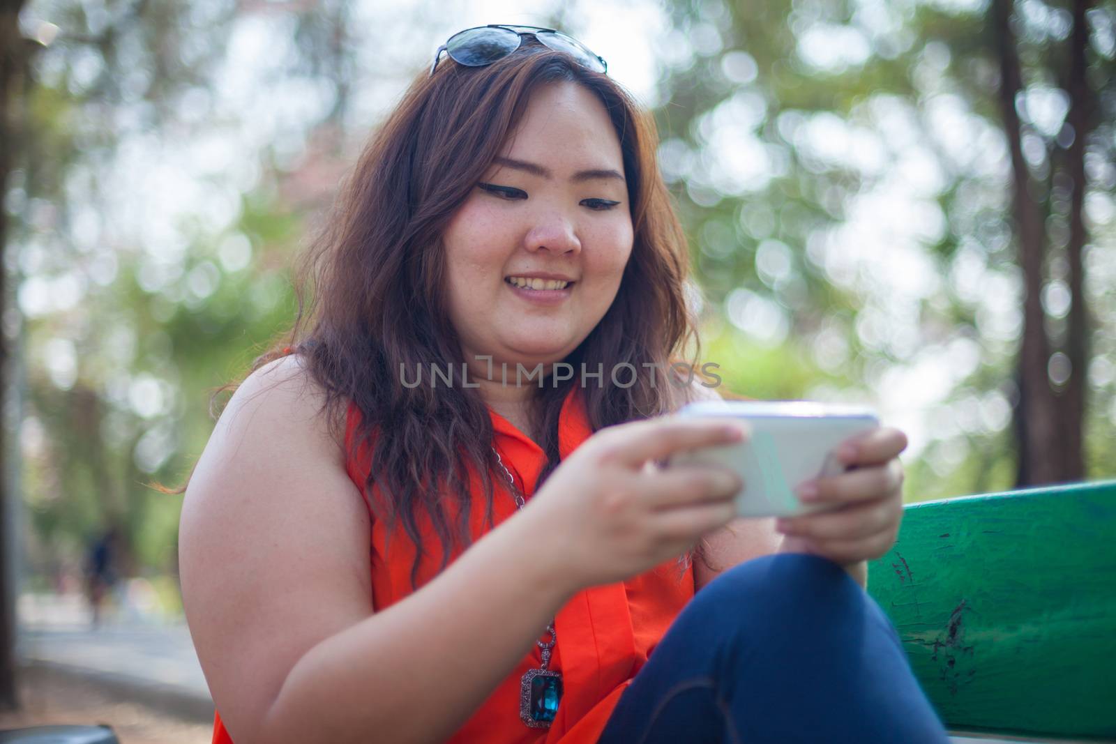 Happy fatty woman using mobile phone by witthaya