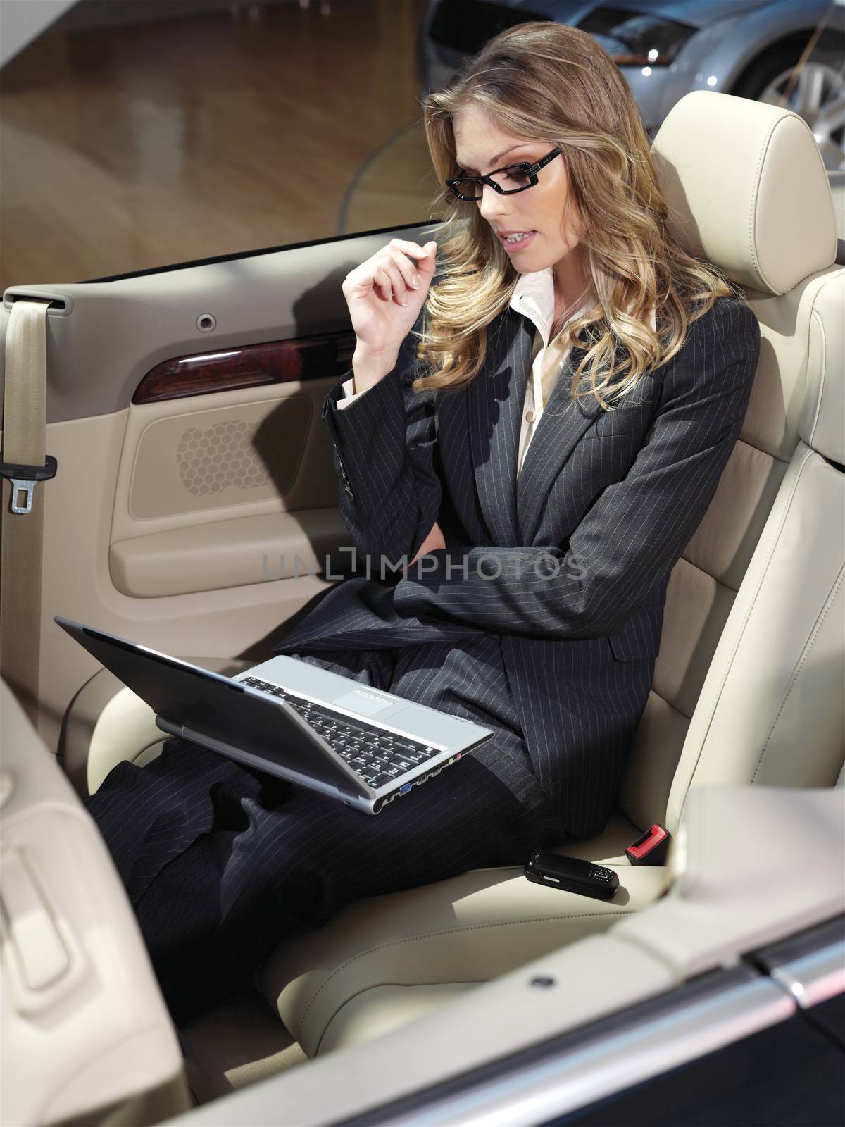 businesswoman has a fan with laptop in black car 