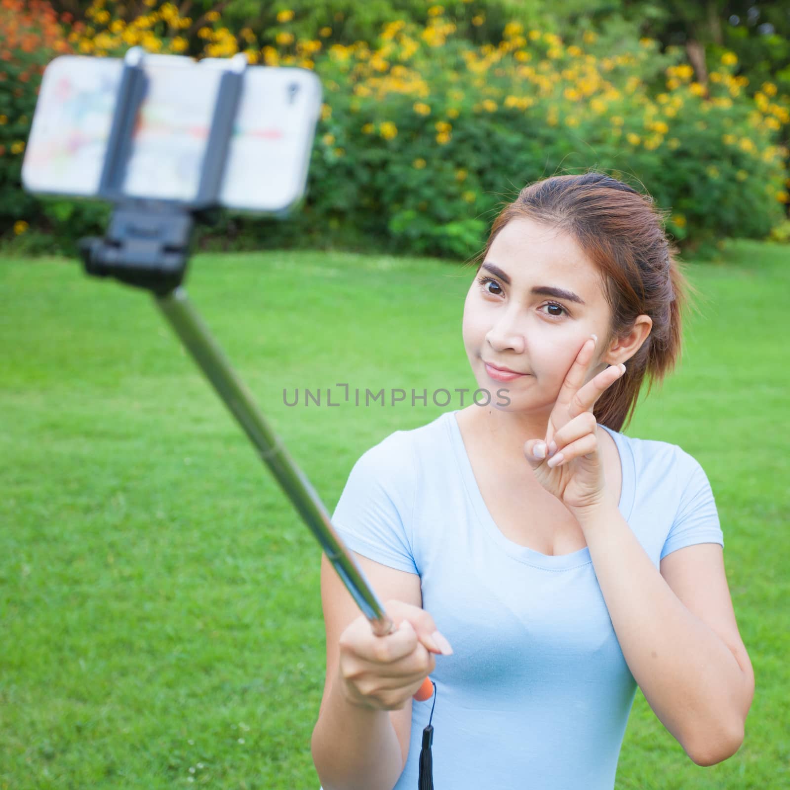 Pretty young female tourist takes travel selfie by witthaya