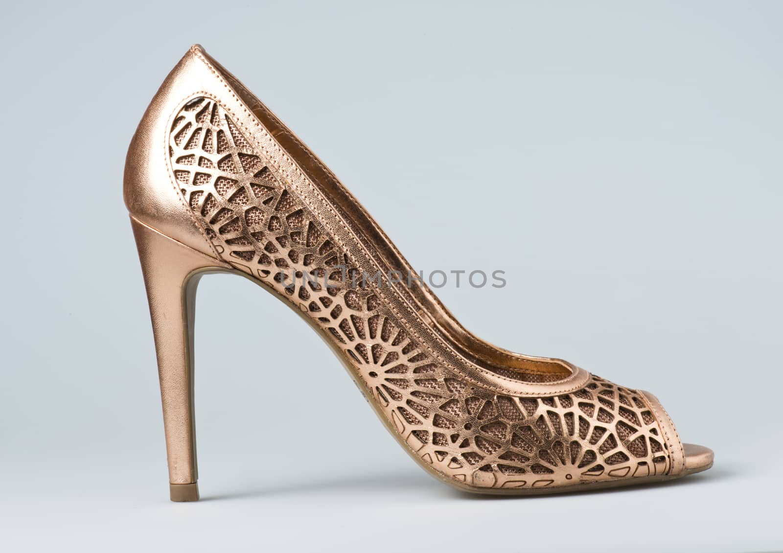 Woman gold shoes on gray background