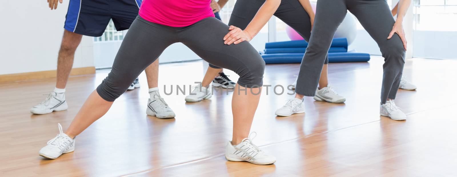 Low section of people doing power fitness exercise at yoga class in fitness studio