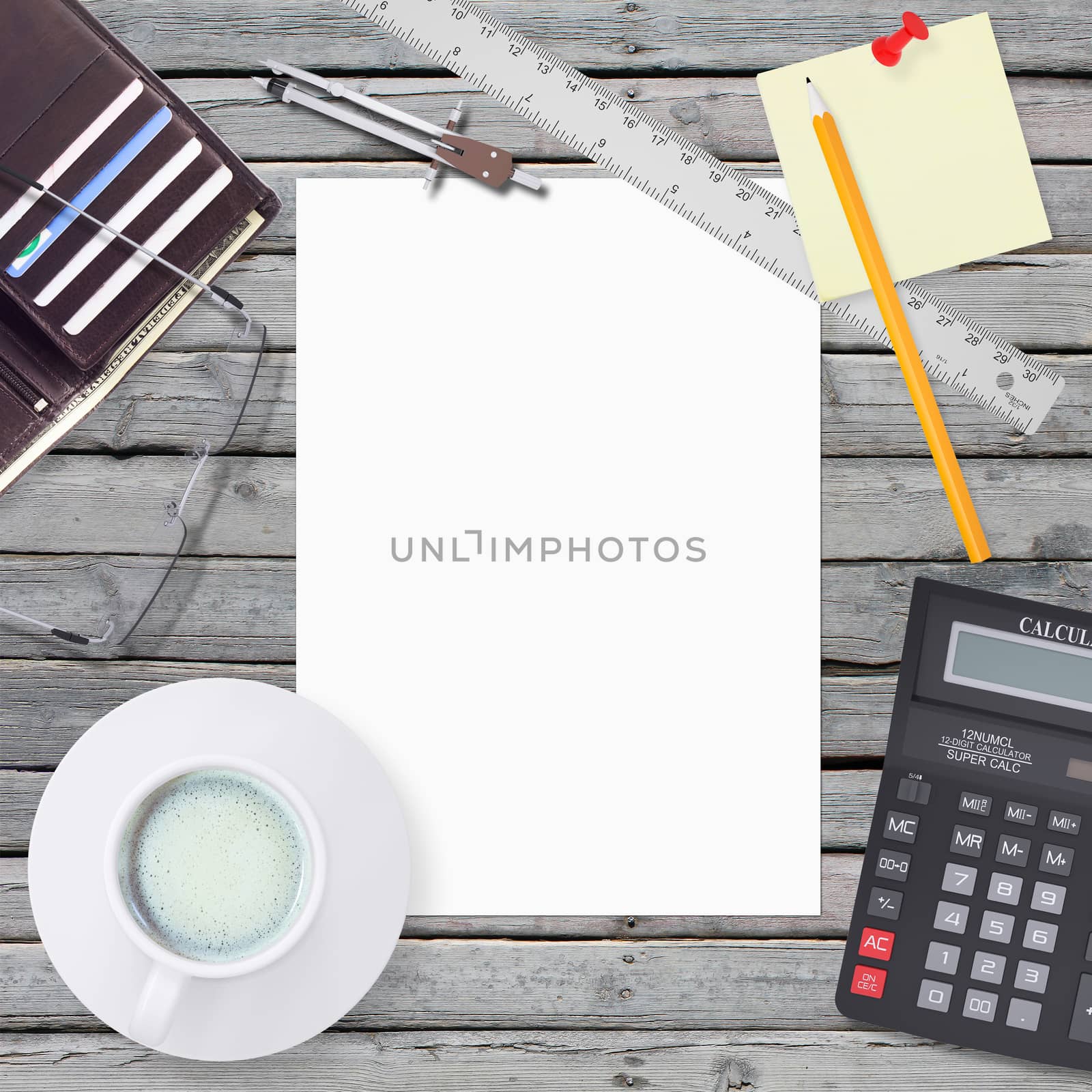 Wooden desktop surface with stationery. White blank sheet in the center