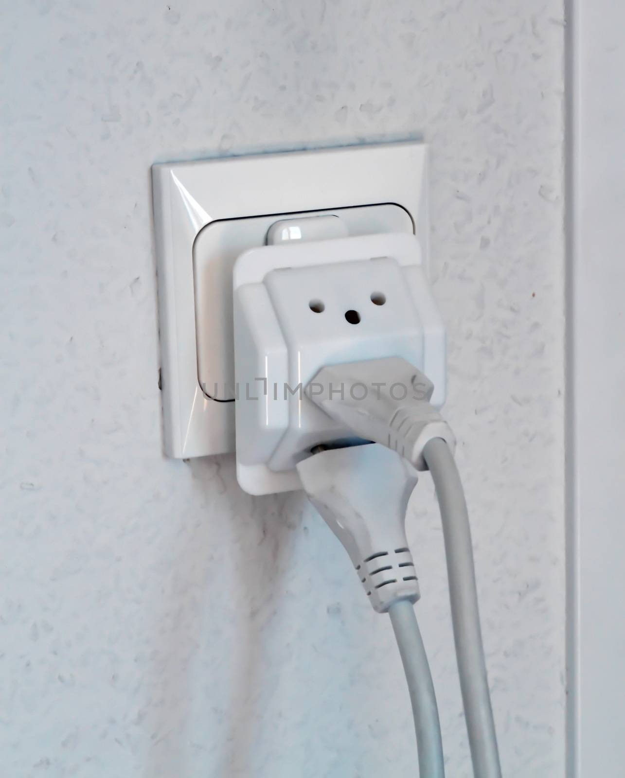 Multiple electrical plugs in wall outlet by Elenaphotos21