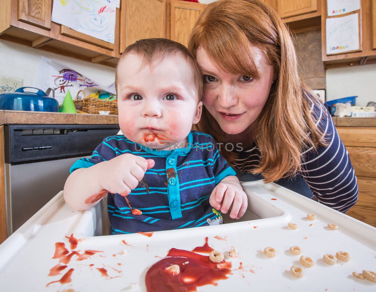 A woman feeds her baby breakfast in the kitchen
