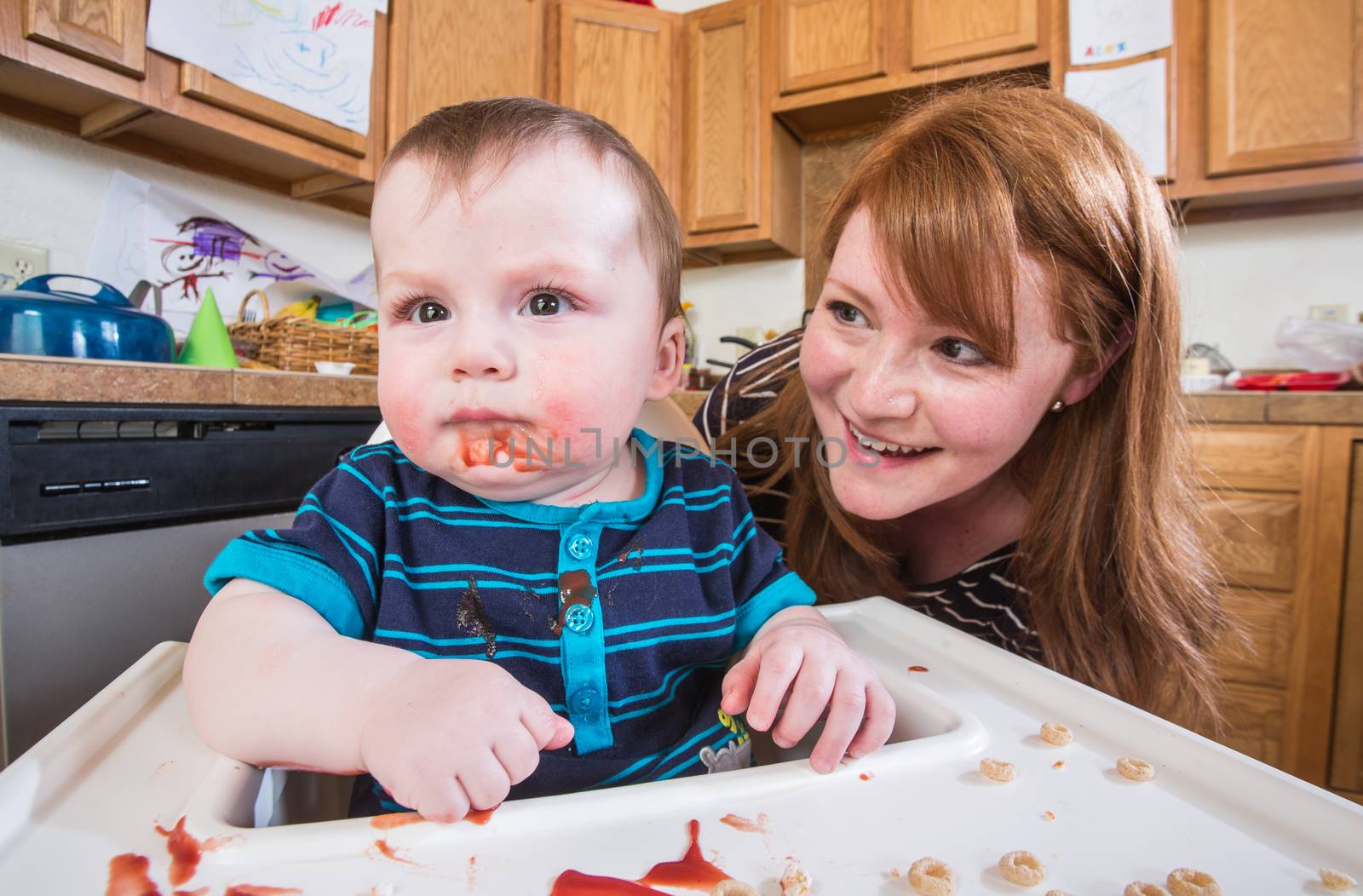 Woman Feeds Baby in Kitchen by Creatista