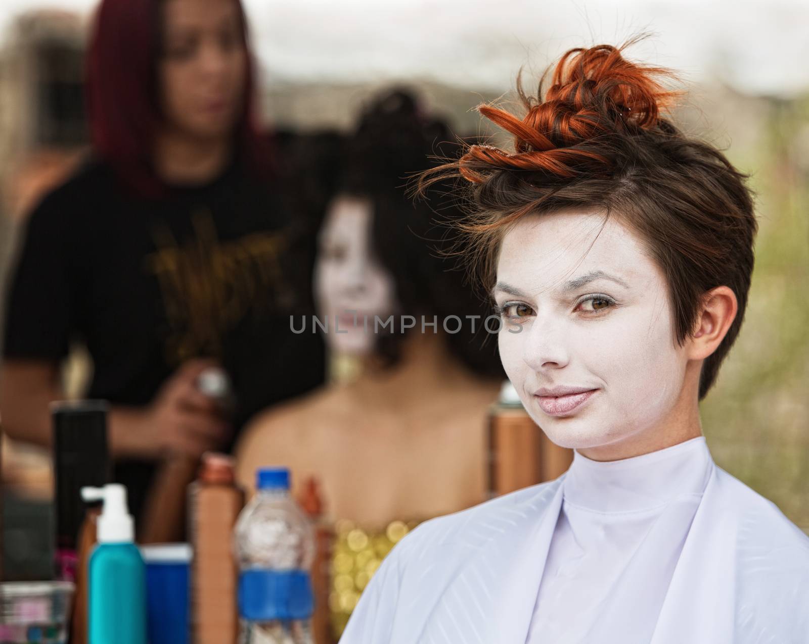 Young female actress in white make up sitting