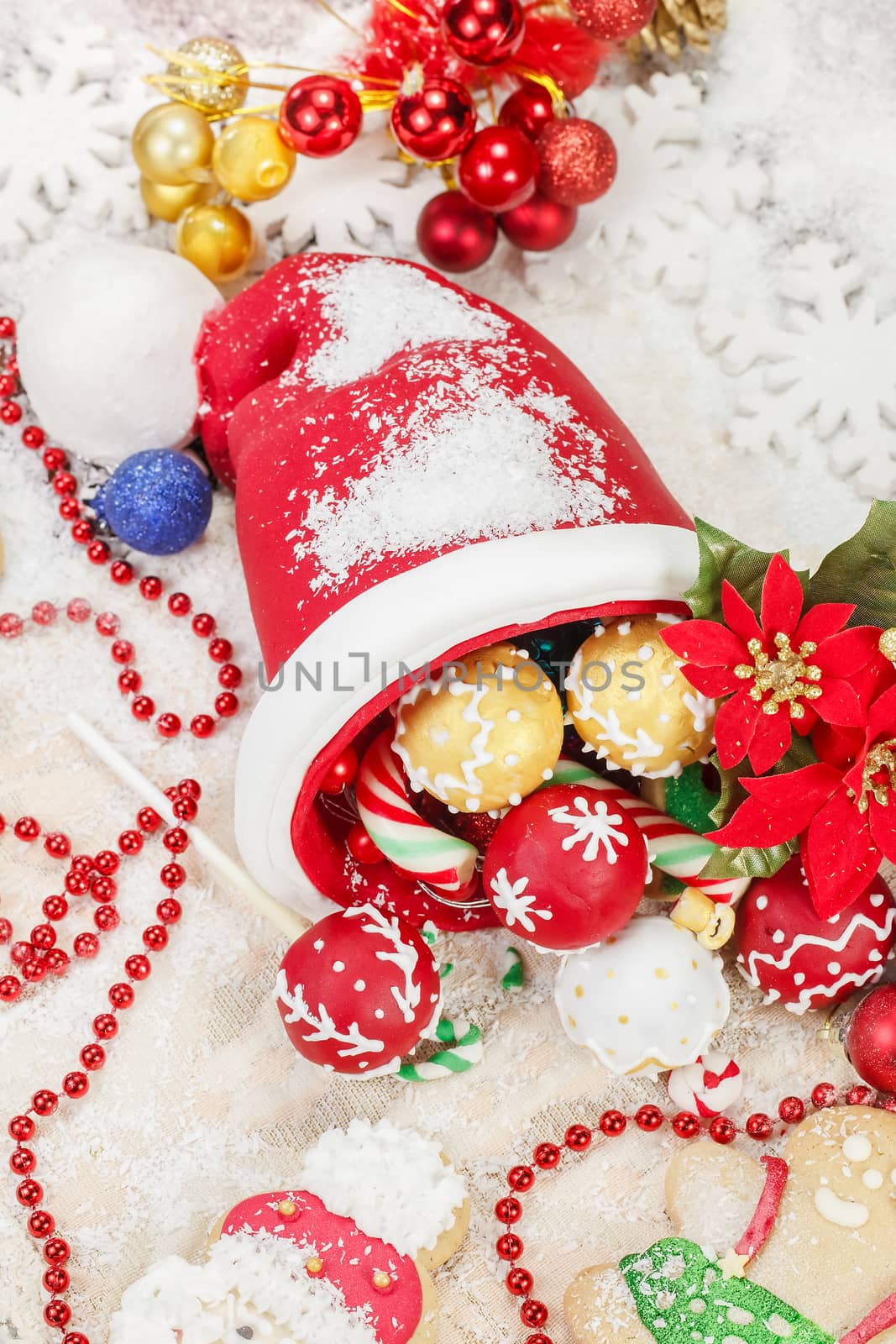 Sweet Sugar Santa Hat, decorated with festive royal icing and Christmas cookies on festive table. Selective focus