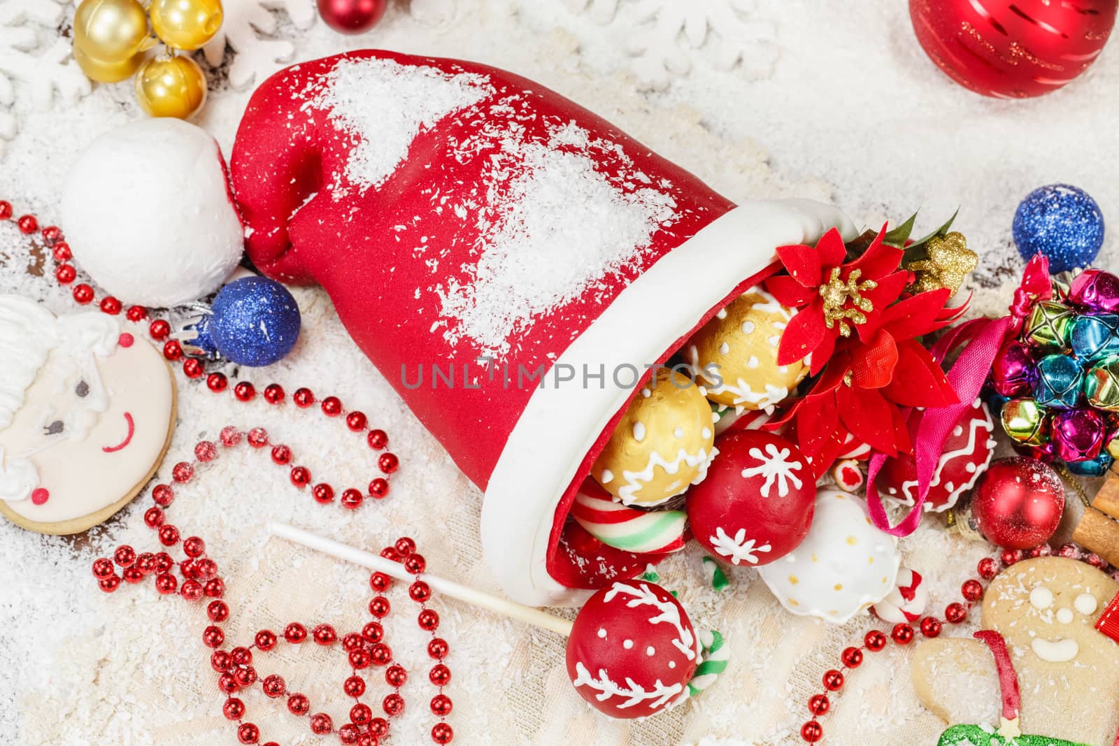Sweet Sugar Santa Hat, decorated with festive royal icing and Christmas cookies on festive table. Selective focus