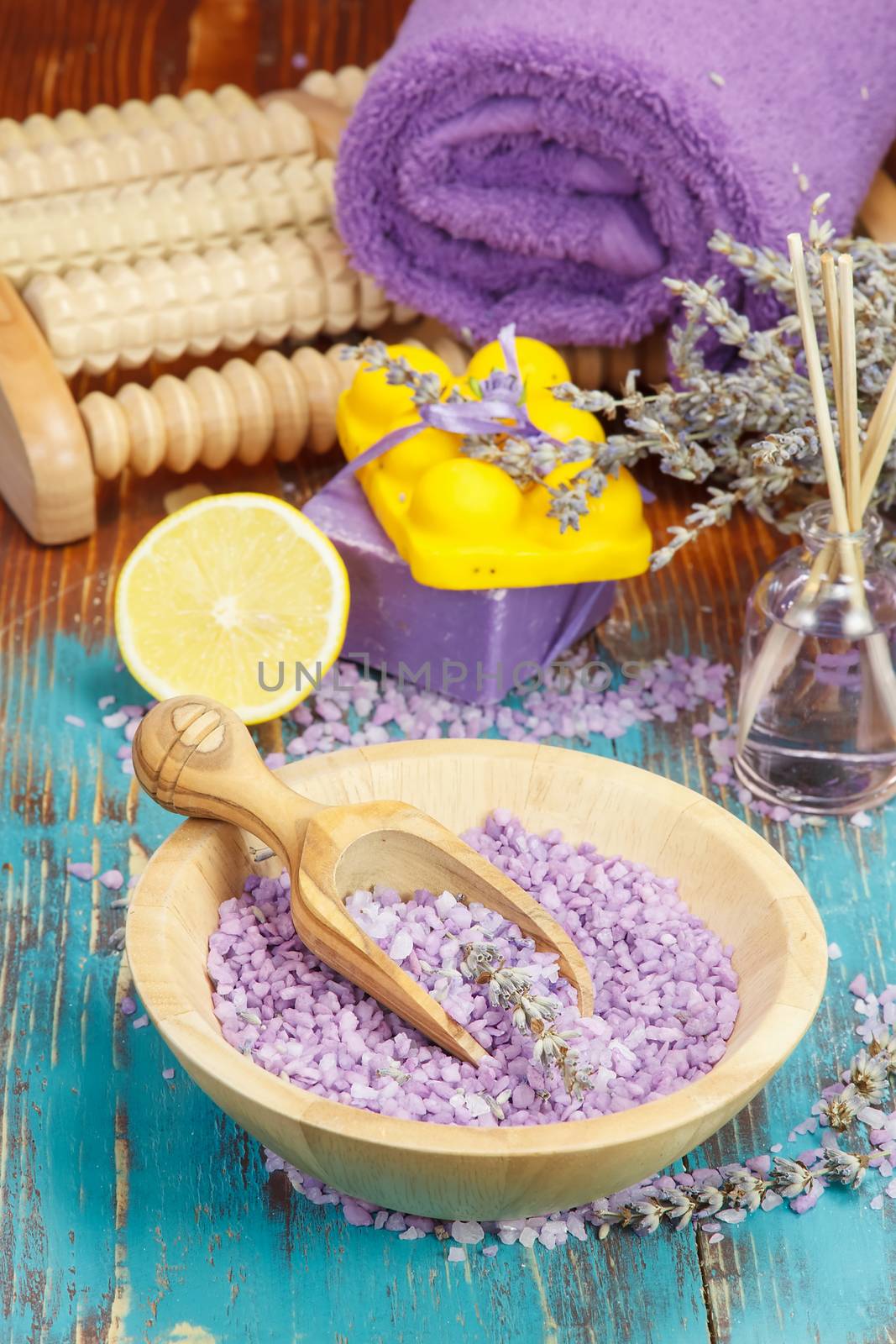 Natural handmade lavender oil, foot massager, soap with bath salt and lavender on wooden background. Macro, selective focus