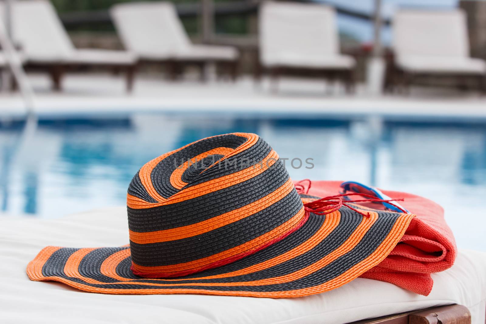 Sunbathing accessories on beach towel by a swimming pool
