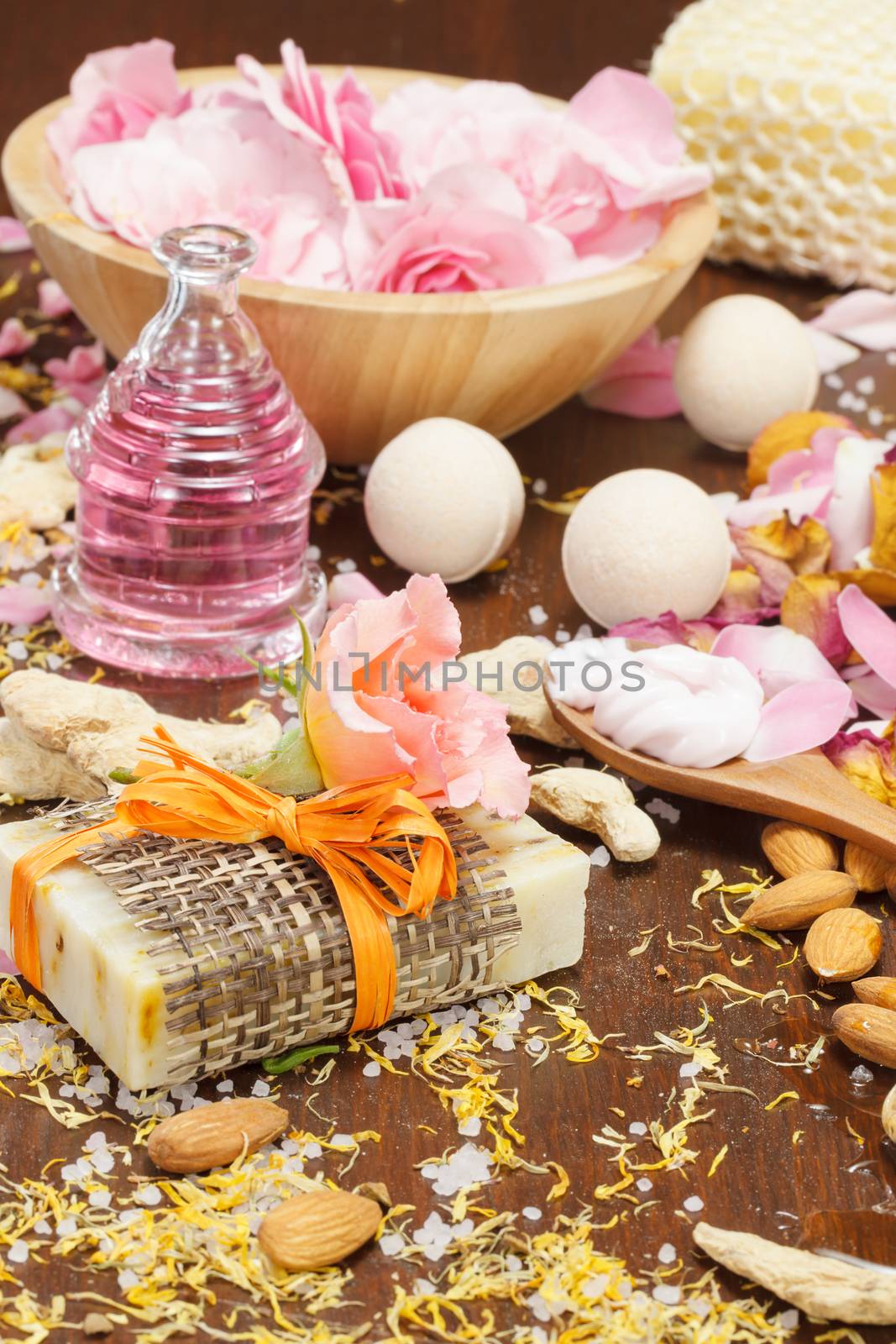 Fizzy bath bomb with natural handmade soap, rose petals and almonds, homemade spa concept. Selective focus