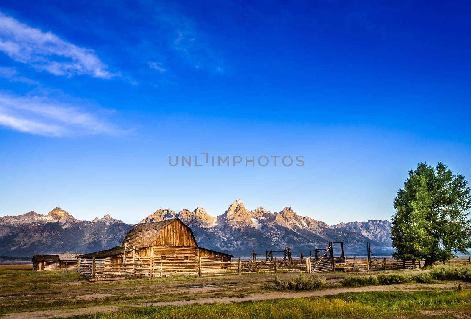 Landscape view of Grand Teton mountain range and abandoned barn by martinm303