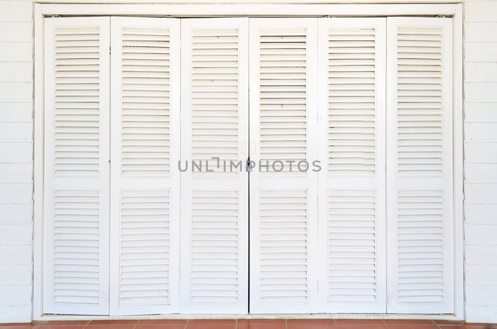 White wooden doors are closed and locked with a key.
