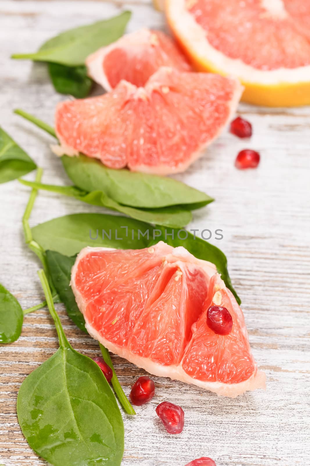 Grapefruit with slices on a wooden table.